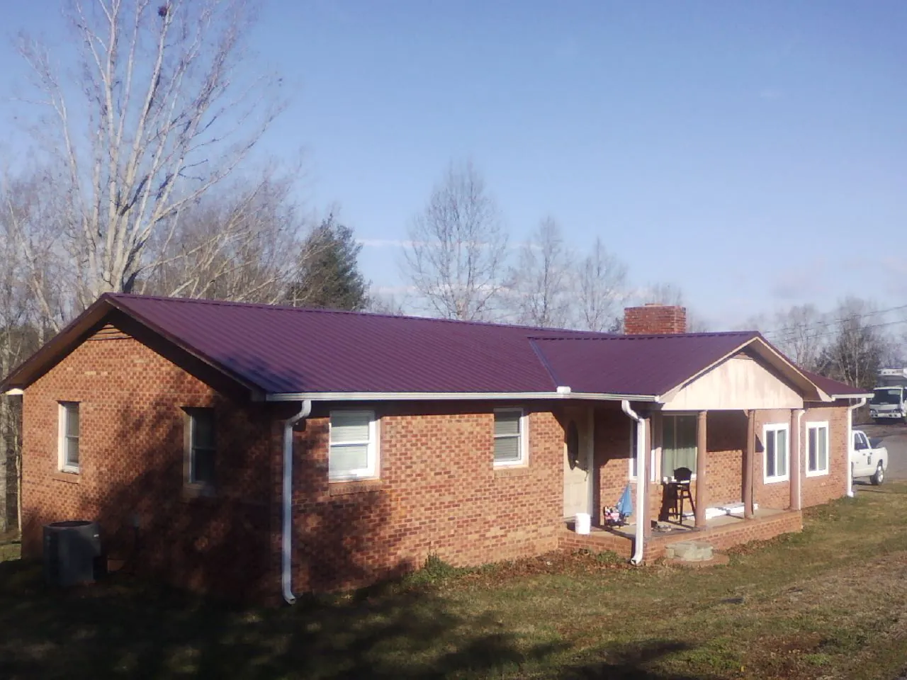 Burgundy metal roof on a brick ranch home with a new addition in Haltom City