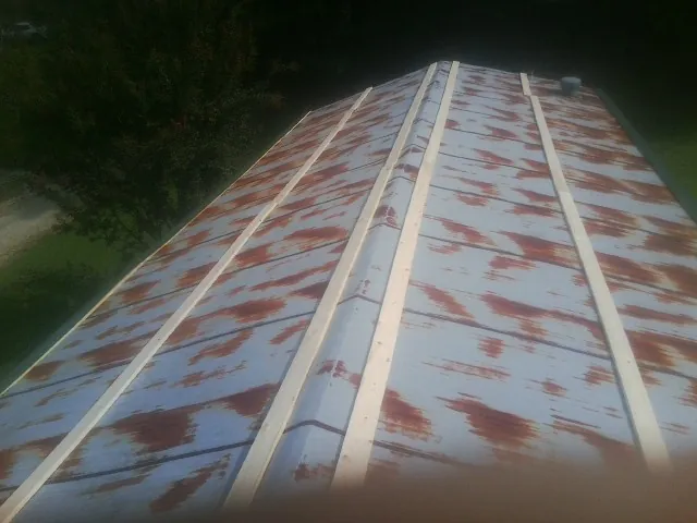 Rusted metal roof panels with new wood purlins before replacement — Storm Damage Roof Repair in Haltom City by Roofing Brothers