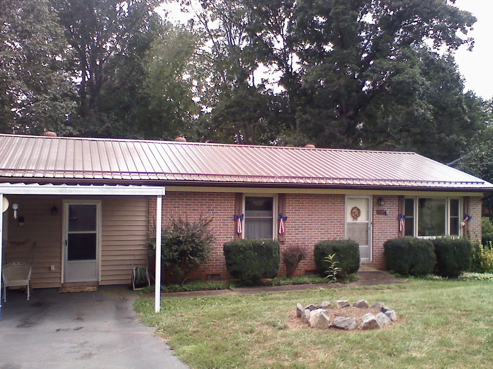 Bronze metal roof and carport on a brick ranch home — Roof Repair work by our crew in Haltom City