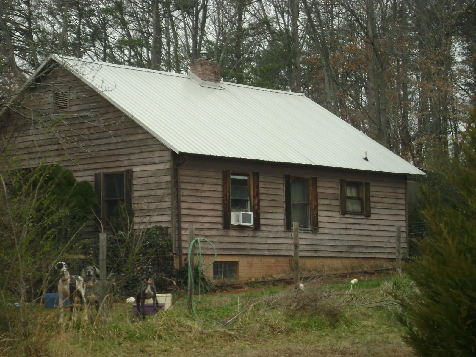 White metal roof on an old wood sided farmhouse, from a Metal Roof Installation job in Haltom City